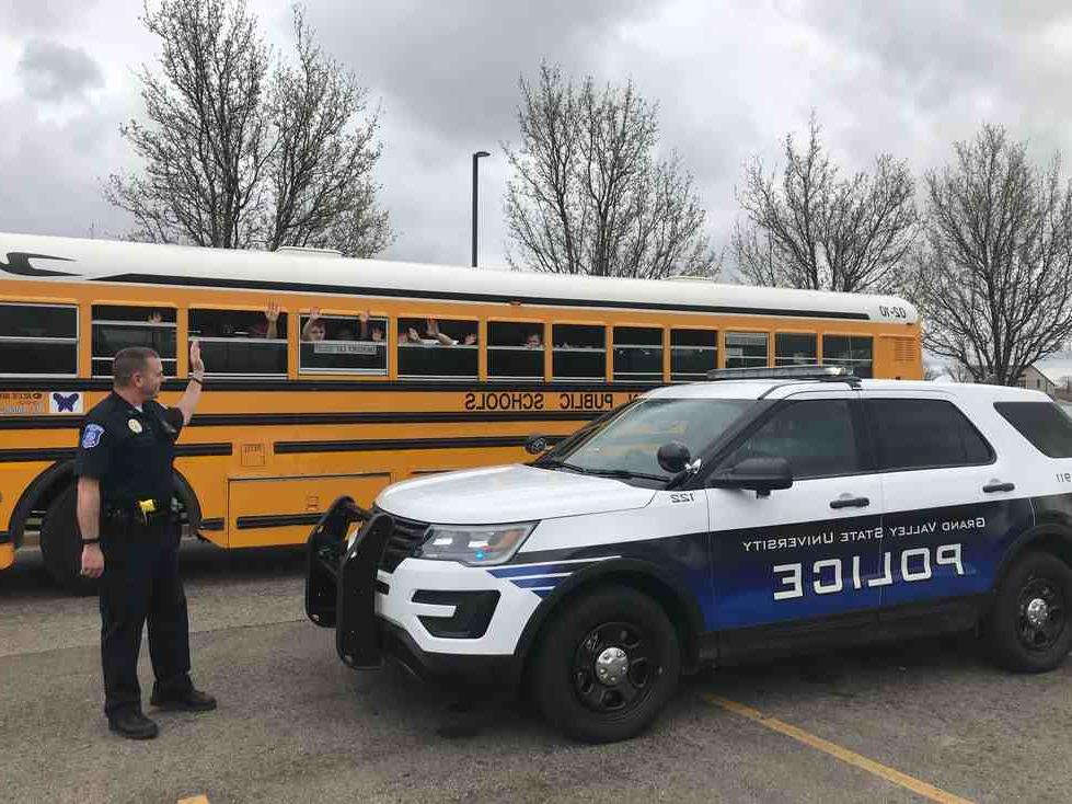Officers waving at a school bus